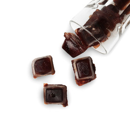 Overturned glass with coffee ice cubes on white background