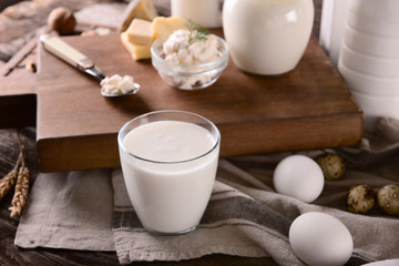 Glass of milk with eggs on wooden table