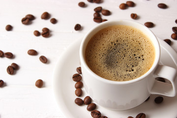 Cup of aromatic coffee and coffee beans on wooden background. Top view. Coffee drink