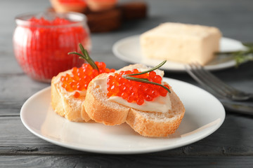 Delicious sandwiches with red caviar on plate