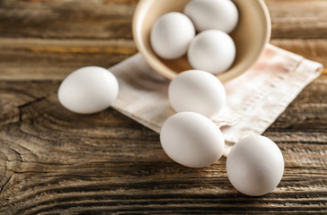 Raw chicken eggs on wooden table