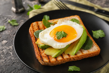 Toasted bread with tasty fried egg on plate
