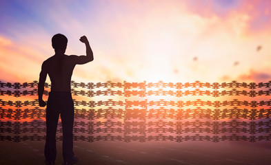International human rights day concept: Silhouette of man raised hands at   sunset background