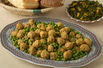 Dish with Moroccan style minced chicken balls and green peas