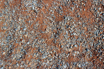 Gravel red dirt road surface texture close up