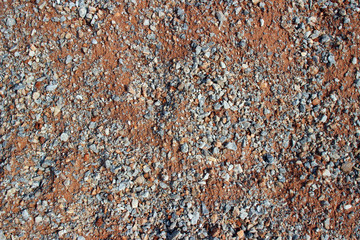 Gravel red dirt road surface texture close up