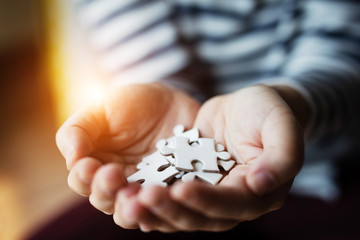 White connecting jigsaw puzzle on hand