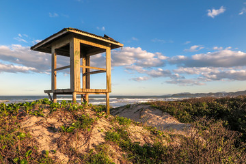 Lifeguard hut on Navegantes beach in the late afternoon, with dunes and native vegetation, blue sky with clouds, Navegantes, Santa Catarina