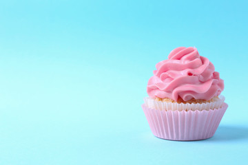 Tasty cupcake on color background