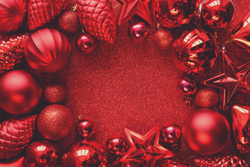 Red Christmas frame. Christmas balls, stars, cones and hearts on red sparkles background. Flat lay....