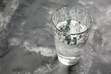Glass of fresh water on grey table