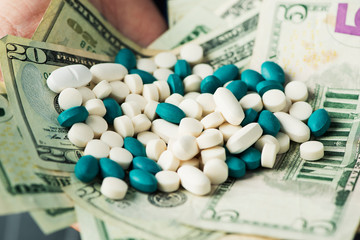 businessman with a pile of pills and dollar bills