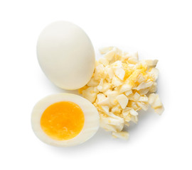 Whole and cut boiled eggs on white background