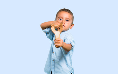 Little kid with slingshot on color baackground