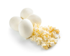 Whole and cut boiled eggs on white background