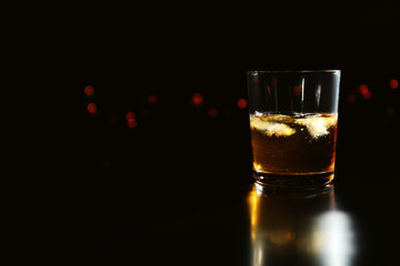 Glass of whiskey on dark background