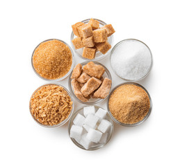 Bowls with different kinds of sugar on white background