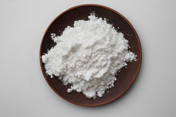 Plate with powdered sugar on light background