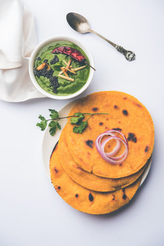 Makki di roti with sarson ka saag, popular punjabi main course recipe in winters made using corn breads mustard leaves curry. served over moody background. selective focus