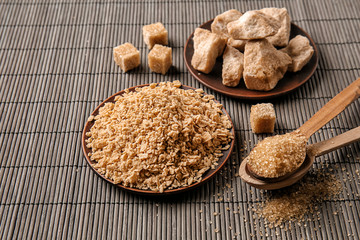 Plates and spoons with varieties of sugar on table