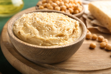 Bowl with hummus on board, closeup