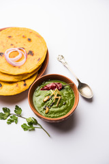 Makki di roti with sarson ka saag, popular punjabi main course recipe in winters made using corn breads mustard leaves curry. served over moody background. selective focus
