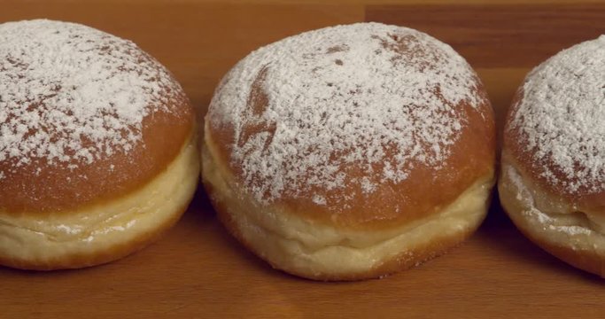 Dolly-shot over jam-filled and sugar-dusted donuts