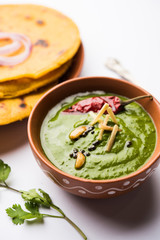 Makki di roti with sarson ka saag, popular punjabi main course recipe in winters made using corn breads mustard leaves curry. served over moody background. selective focus