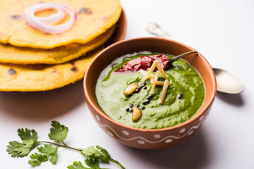 Makki di roti with sarson ka saag, popular punjabi main course recipe in winters made using corn breads mustard leaves curry. served over moody background. selective focus