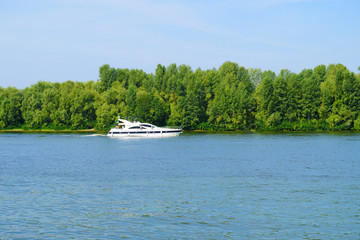 View of one boat in the river against a green forest.