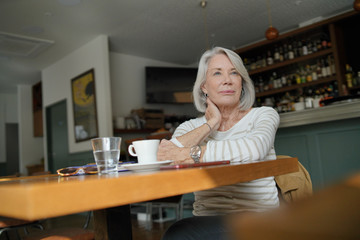  Elegant senior woman thinking in a restaurant
