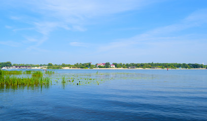 Beautiful spring landscape of river and forest green in the distance.