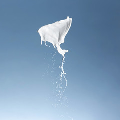 Obraz na płótnie Canvas Splash of milk on color background