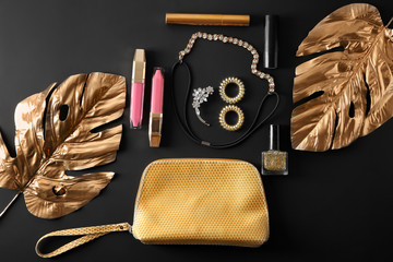 Flat lay composition with cosmetics and accessories on black background