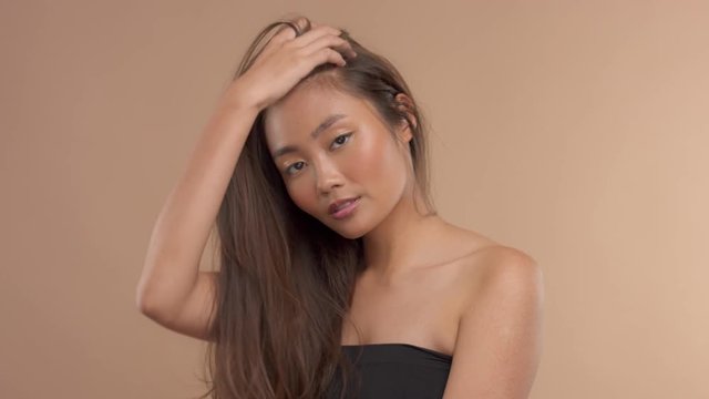 slow motion beauty thai asian model touches her hair. Studio video portrait focused en hair beauty