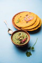 Makki di roti with sarson ka saag, popular punjabi main course recipe in winters made using corn breads mustard leaves curry. served over moody background. selective focus