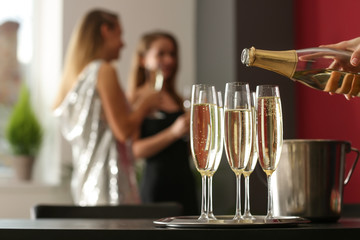 Waiter pouring champagne in glasses at party