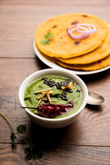 Makki di roti with sarson ka saag, popular punjabi main course recipe in winters made using corn breads mustard leaves curry. served over moody background. selective focus
