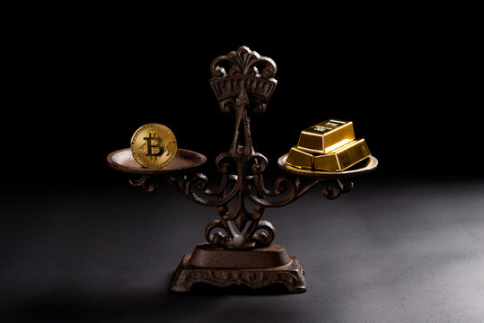 bitcoin and gold bars on a balanced scale concept of the value of bitcoins