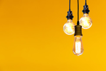 Vintage light bulb hanging over yellow  background, Idea concept.