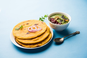 Makki di roti with sarson ka saag, popular punjabi main course recipe in winters made using corn breads mustard leaves curry. served over moody background. selective focus