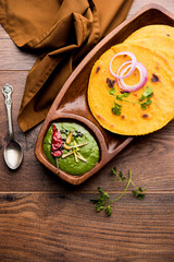 Makki di roti with sarson ka saag, popular punjabi main course recipe in winters made using corn breads mustard leaves curry. served over moody background. selective focus