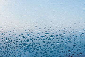 Strong humidity in wintertime. Water drops from home condensation on a window. Misted glass background