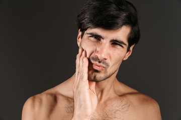 Obraz premium Displeased young man with toothache posing isolated over dark wall background.