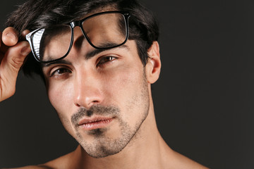 Obraz premium Young man isolated over dark background wearing eyeglasses.