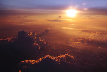 The view from the window of the plane on the clouds and the evening sun. Travel to vacation, a ticket for the evening flight. Beautiful sunset. 