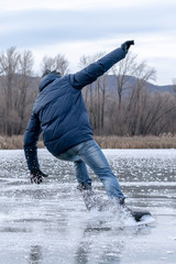 Man falling down while ice skating. Snow skates from the scatter in the parties.