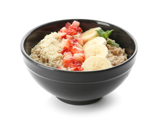 Bowl with tasty oatmeal, sliced banana and strawberry on white background