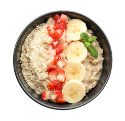 Bowl with tasty oatmeal, sliced banana and strawberry on white background
