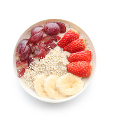 Bowl with tasty oatmeal, fruits and strawberry on white background